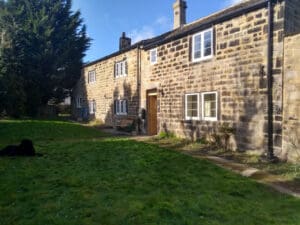 Historic stone farmhouse with upgraded timber windows featuring energy-efficient LandVac vacuum glazing, preserving the traditional character while improving insulation.