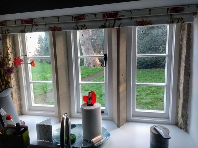 Interior view of a restored farmhouse window with LandVac vacuum glazing in original stone frame, preserving historical character while improving energy efficiency.